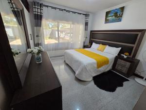 a bedroom with a large bed and a window at Mel's Apartment in Ndola