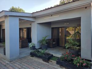 a house with potted plants on a patio at Mel's Apartment in Ndola