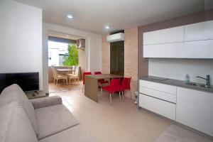 a kitchen and living room with a couch and a table at Apartmani Daška II in Njivice