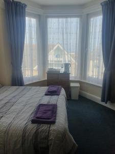 a bedroom with a bed with purple towels on it at Smugglers Rest in Newquay