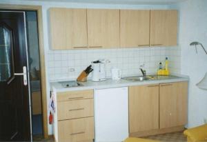 a kitchen with wooden cabinets and a sink at Ück - Biedenweg in Ueckeritz