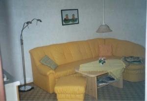 a living room with a yellow couch and a table at Ück - Biedenweg in Ueckeritz