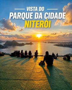 a group of people sitting on the ground watching the sunset at Apartamento Nictheroy in Niterói +4 photos