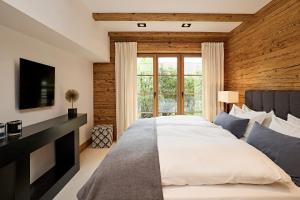 a bedroom with a large bed and a television at Chalet-F in Ofterschwang