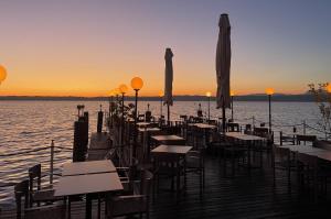 a row of tables and umbrellas on a pier with the ocean at Hotel Pace in Sirmione