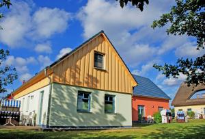 a barn style house with a gambrel roof at Ferienappartements zum Ostseestrand mit Terrasse in Lobbe