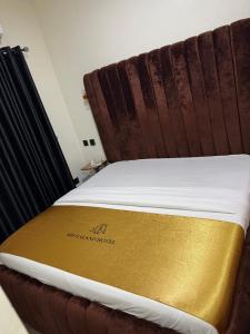 a bed with a gold blanket on top of it at Shugaland hotel and lounge in Ibadan +3 photos