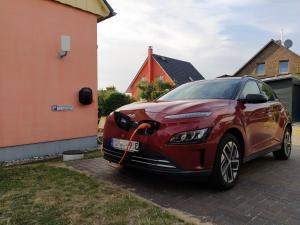a red car parked next to a house at Ferienappartements zum Ostseestrand mit Terrasse in Lobbe