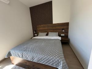 a bedroom with a bed with a wooden headboard at Zenith Lux Apartment Beachfront & Parking in Bijela