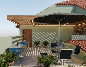 a patio with a table and chairs and an umbrella at Pérola Suítes Boutique Hotel in Luanda