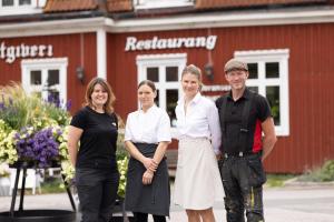 a group of people standing in front of a red building at Blankaholms Gästgiveri in Blankaholm
