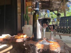 two glasses of wine on a table with a bottle of wine at Il wokini in Castel Vittorio