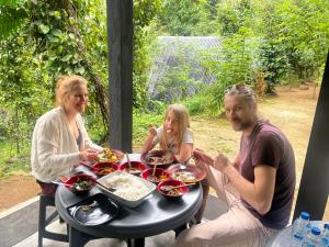 a group of people sitting at a table eating food at Pepper Trails Riverstone in Polwattekanda