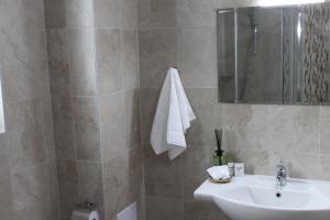 a bathroom with a sink and a mirror at Sea & Hill Guest Houses хотелски тип in Lozenets +19 photos