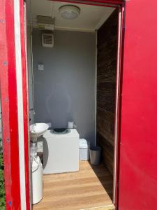 a small bathroom with a toilet and a sink at Happy Meadows - The Chick Inn in Long Stratton