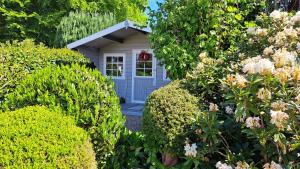 a small white house with a red wreath in a garden at "Ferienhaus Großenaspe" in Großenaspe +17 photos