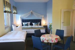a bedroom with a bed and a table with chairs at Bed & Breakfast am Waldgürtel in Forst