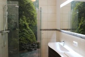 a bathroom with a shower and a sink and a window at Bed & Breakfast am Waldgürtel in Forst