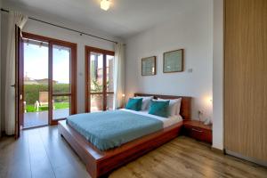 a bedroom with a bed and a large window at Ground floor Apartment Anthos with Beautiful Sea Views on Aphrodite Hills Resort in Kouklia +32 photos