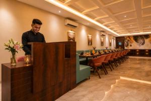 a man standing behind a bar in a restaurant at Vijay Vilas by Arow Hotels and Resorts in Pushkar +79 photos
