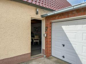 a garage door of a brick house with a table at Ferienwohnung Sperlingslust in Niepars