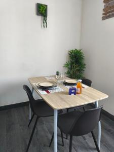 a wooden table with chairs and plates and drinks on it at point baie studio 1 in Abbeville +4 photos