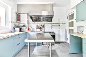 a kitchen with blue and white cabinets and a sink at Maroutine - AC - Piscine & Tennis in Labouheyre