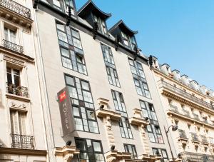 un bâtiment avec un panneau sur son côté dans l'établissement ibis Paris Bastille Faubourg St Antoine, à Paris