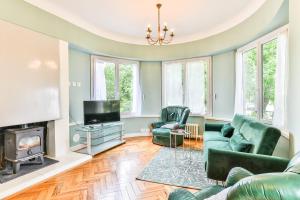 a living room with green furniture and a tv at Maroutine - AC - Piscine & Tennis in Labouheyre +16 photos