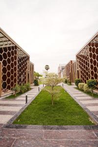 a courtyard with a tree in between two buildings at Sandy Resort in Agastīswaram