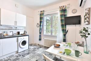a kitchen with a table and a sink and a dishwasher at Lavignottes - AC - Piscine & Tennis in Labouheyre