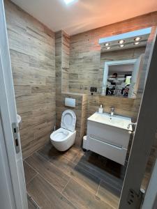 a bathroom with a toilet and a sink at No Stress in Borča +10 photos