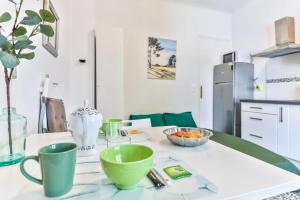 a kitchen with a table with green cups on it at Lavignottes - AC - Piscine & Tennis in Labouheyre
