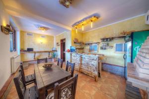 a kitchen and dining room with a wooden table and chairs at Rhodope House Momchil Yunak in Momchilovtsi