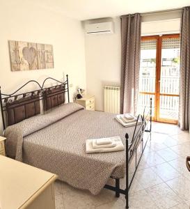 a bedroom with a bed with two towels on it at MARINE KISS- Appartamento con PARCHEGGIO PRIVATO GRATUITO- Vicino Porto Crociere e Stazione in Civitavecchia +43 photos
