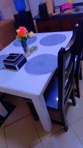 a white table with a vase of flowers on it at Pebs one bedroom apartment in Mombasa