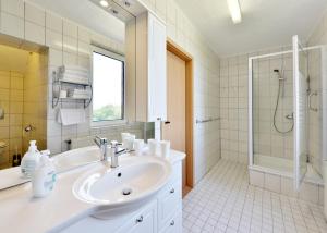 a white bathroom with a sink and a shower at Hotel Gesellschaftshaus in Bergen auf Rügen +34 photos