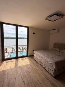 a bedroom with a bed and a view of the water at No Stress in Borča