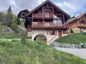 a large wooden house with a balcony on a hill at Chalet Face aux Etoiles in Molines-en-Queyras