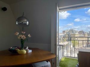 a vase of flowers on a table next to a window at Eiffel Tower View Apartment in Paris