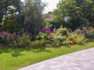 a garden with colorful flowers and a sidewalk at Luzie's Hus in Freest