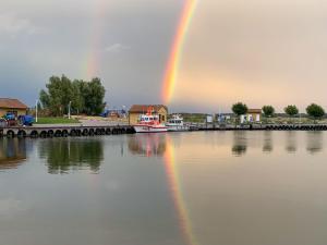 a rainbow over a body of water with a boat at Luzie's Hus in Freest