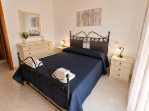 a bedroom with a blue bed and two night stands at MARINE KISS- Appartamento con PARCHEGGIO PRIVATO GRATUITO- Vicino Porto Crociere e Stazione in Civitavecchia