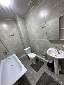 a bathroom with a tub and a toilet and a sink at RADUGA West in Koshkolʼ
