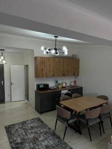 a kitchen and dining room with a table and chairs at RADUGA West in Koshkolʼ