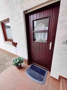a purple door with a window and a potted plant at Ferienwohnung Edersonne in Hemfurth-Edersee