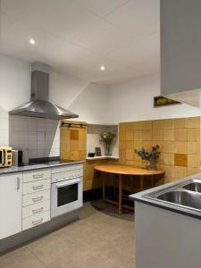 a kitchen with white cabinets and a wooden table at Rambla Riverview in Girona