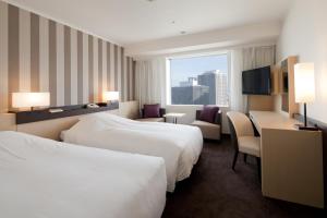 a hotel room with two beds and a window at Hotel Granvia Osaka-JR Hotel Group in Osaka