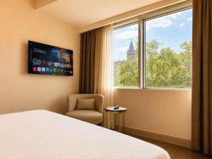a hotel room with a bed and a chair and a window at The Tram Karakoy in Istanbul
