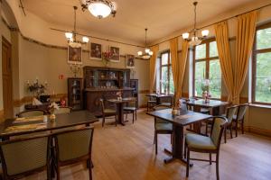 a dining room with tables and chairs and windows at Hotel Jagdschloss Letzlingen in Letzlingen